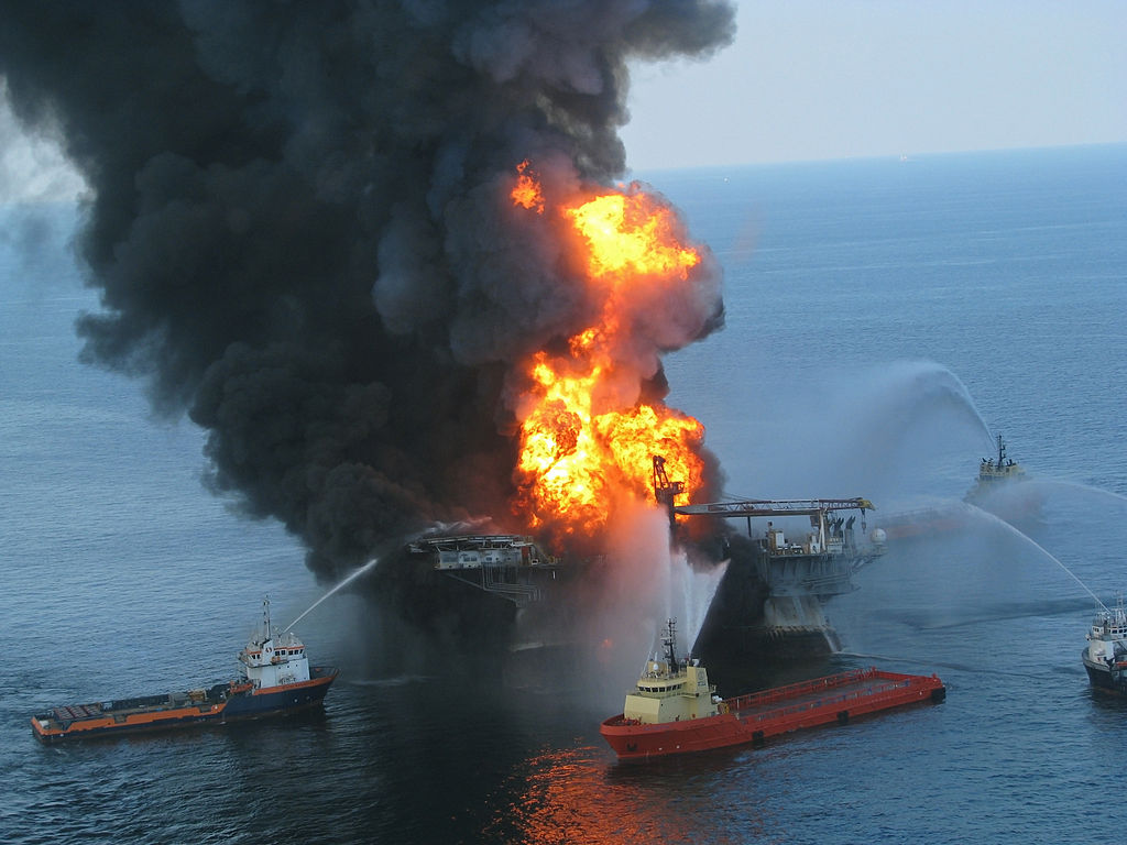 Platform supply vessels battle the blazing remnants of the off shore oil rig Deepwater Horizon. A Coast Guard MH-65C dolphin rescue helicopter and crew document the fire aboard the mobile offshore drilling unit Deepwater Horizon, while searching for survi