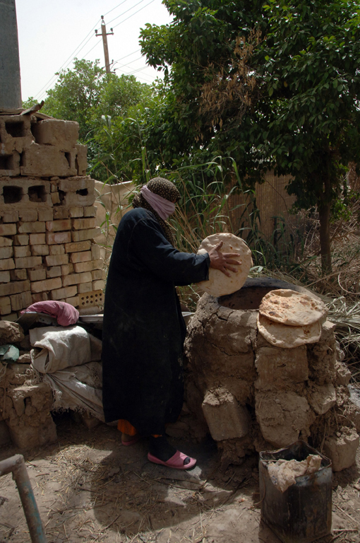 In Iraq, ancient bread making methods are still used today. In this photograph, an Iraqi woman is baking bread for US soldiers. 